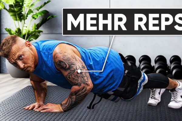 Miniaturansicht des Videos "Mit diesem Trick 50% mehr Liegestütze schaffen" vom Kanal CoachStef: CoachStef in Sportkleidung zeigt eine Liegestütz-Position, im Hintergrund ist ein Fitnessstudio zu sehen.