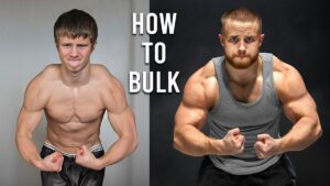 Thumbnail for Jeff Nippard's video "How To Bulk Like A Pro (Using Science)" featuring Jeff flexing his arm muscles, with text overlay highlighting key points about effective bulking strategies using scientific principles.